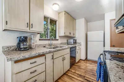 a kitchen with wooden cabinets and a white refrigerator at Redwood Escape in Arnold