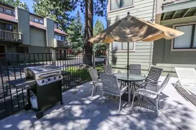 a patio with a table and a grill and chairs at Mammoth Sierra Townhome in Mammoth Lakes