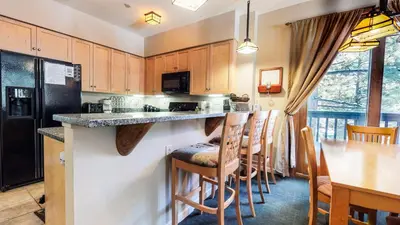 a kitchen with a bar and a table with chairs at Mammoth Green #111 condo in Mammoth Lakes