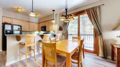 a kitchen and dining room with a wooden table and chairs at Mammoth Green #111 condo in Mammoth Lakes