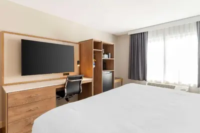 a hotel room with a bed and a flat screen tv at Best Western Plus Rancho Cordova Inn in Rancho Cordova