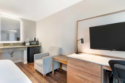 a hotel room with a large flat screen tv at Best Western Plus Rancho Cordova Inn in Rancho Cordova