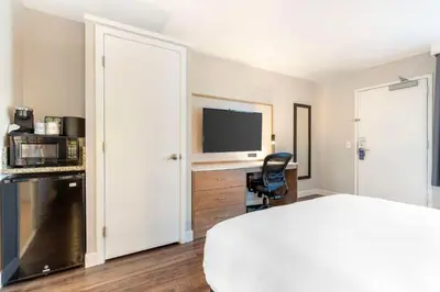 a bedroom with a bed and a desk with a television at Best Western Plus Rancho Cordova Inn in Rancho Cordova