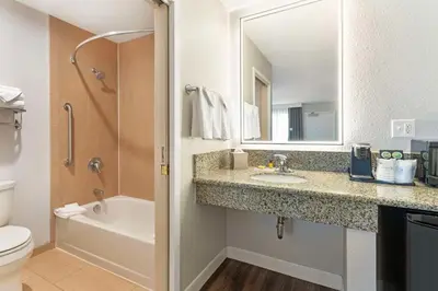 a bathroom with a sink and a toilet and a mirror at Best Western Plus Rancho Cordova Inn in Rancho Cordova