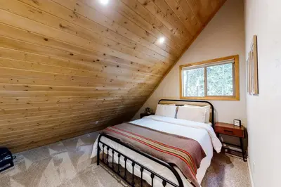 a bed in a room with a wooden wall at Truckee Secret in Truckee