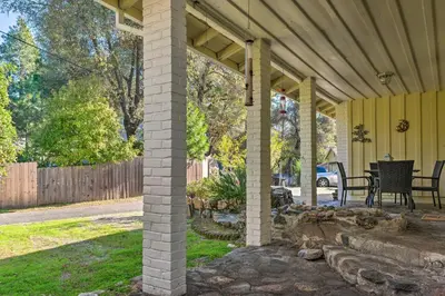 a covered porch of a house with a table and chairs at Wine Country Escape with Hot Tub in River Pines! in River Pines