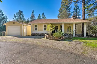 a yellow house with a garage and a driveway at Wine Country Escape with Hot Tub in River Pines! in River Pines
