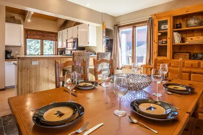 a wooden table with wine glasses and plates on it at Sunrise 9 in Mammoth Lakes