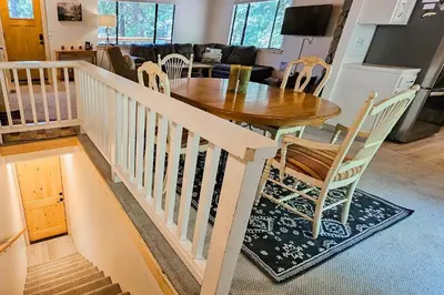 a dining room and living room with a table and chairs at Cabin In The Woods in Arnold