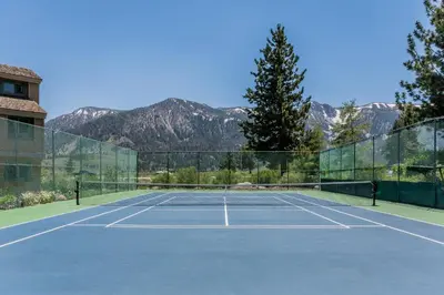 a tennis court with mountains in the background at Mammoth Creek Townhome # 40 Updated 2 bedrooms and Loft 2 and half bath Steps to free town shuttle stop in Mammoth Lakes