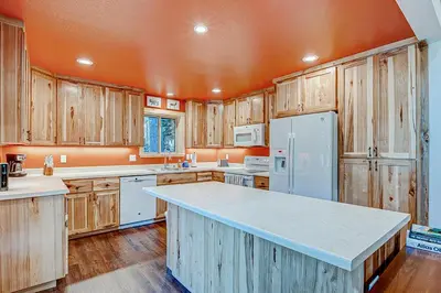 a kitchen with wooden cabinets and a white refrigerator at The Truckee Vibe in Soda Springs