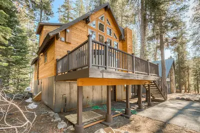 a cabin in the woods with a large deck at The Truckee Vibe in Soda Springs