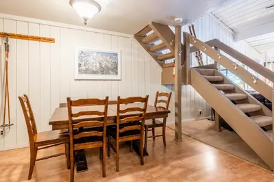 a dining room with a table and chairs and a staircase at New Listing 2 bedroom and Loft 2 bath Summit E Bldg 16 condo sleeps 8 Steps to Eagle Lodge Chair 15 in Mammoth Lakes
