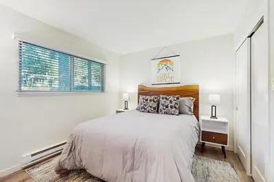 a white bedroom with a bed and a window at Peace Among the Pines in Incline Village