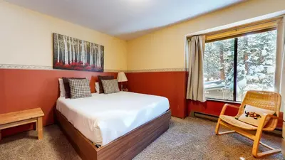a bedroom with a bed and a window and a chair at Horizons 4 #186 condo in Mammoth Lakes