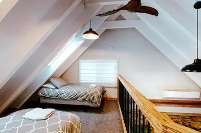 a attic room with two beds and a window at Starfall in Yosemite West