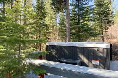 a sauna sitting on a deck in the woods at Cozy Cabin Retreat in South Lake Tahoe