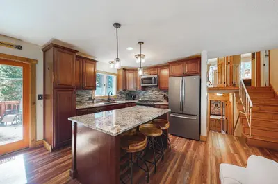 a kitchen with wooden cabinets and a island with bar stools at A River Runs Through It in Incline Village