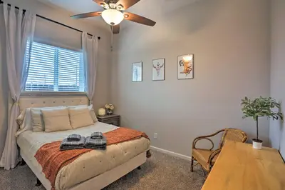 a bedroom with a bed with a ceiling fan and a table at Stunning Clovis Home about 1 Mile to Old Town! in Clovis