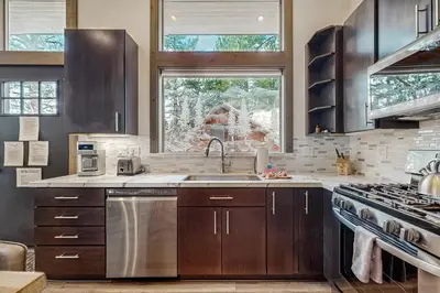a kitchen with wooden cabinets and a sink and a window at Bear's Den in Truckee