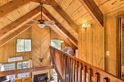 a wooden staircase in a house with a ceiling fan at Near Trails Cabin with 2-Level Deck in Twain Harte in Twain Harte