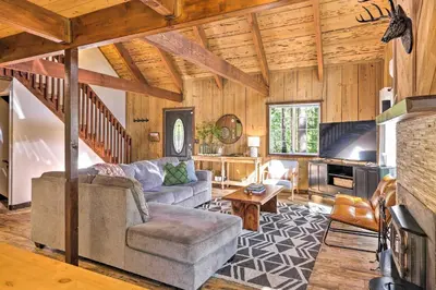 a living room with a couch and a table at Near Trails Cabin with 2-Level Deck in Twain Harte in Twain Harte