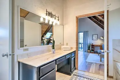 a bathroom with a large mirror and a sink at Modern Groveland Chalet about 25 Mi to Yosemite! in Groveland