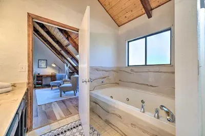 a bathroom with a bath tub in a room at Modern Groveland Chalet about 25 Mi to Yosemite! in Groveland