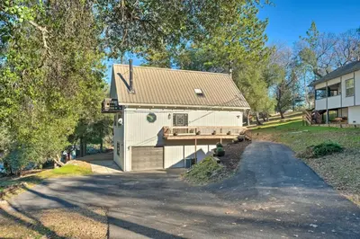 a white barn with a driveway next to a house at Modern Groveland Chalet about 25 Mi to Yosemite! in Groveland