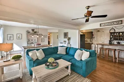 a living room with a blue couch and a table at 1 Mi to Main Street Sutter Creek Poolside Oasis! in Sutter Creek