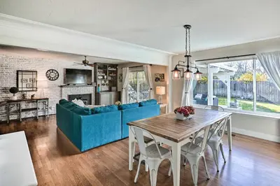 a living room with a blue couch and a table at 1 Mi to Main Street Sutter Creek Poolside Oasis! in Sutter Creek