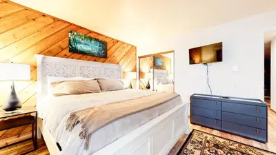a bedroom with a white bed and wooden walls at Snowcreek I #11 condo in Mammoth Lakes