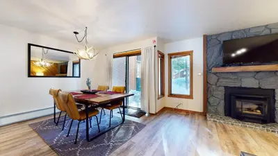 a dining room with a table and a fireplace at Snowcreek I #11 condo in Mammoth Lakes