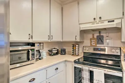 a kitchen with white cabinets and stainless steel appliances at Lakeside Groveland Home with Hot Tub, Near Yosemite in Groveland