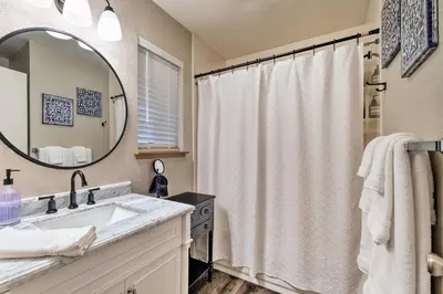 a bathroom with a sink and a shower curtain at Lakeside Groveland Home with Hot Tub, Near Yosemite in Groveland