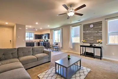 a living room with a couch and a ceiling fan at 4 Mi to City Center Family-Friendly Retreat! in Merced