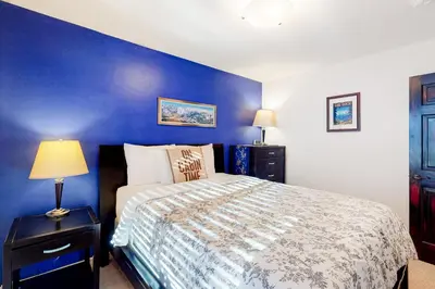 a bedroom with a bed with a blue wall at Back Country Basecamp in Stateline