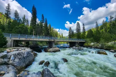 a bridge over a river with rushing water at Majestic Mountain in Dorrington