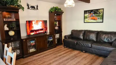a living room with a leather couch and a fire place at Sequoia Trails, mountains, fun & relax in Ponderosa
