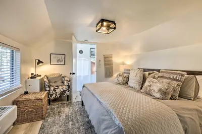 a bedroom with a large bed and a chair at Walk to Lake Tahoe Cozy Zephyr Cove Cabin! in Zephyr Cove