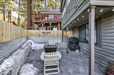 a patio with a chair and a grill on a house at Walk to Lake Tahoe Cozy Zephyr Cove Cabin! in Zephyr Cove