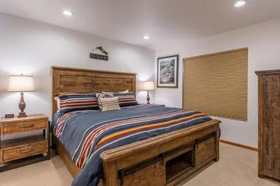 a bedroom with a large wooden bed and a window at Hidden Valley Village #103 nicely updated 1 bedroom 1 bathroom condo short 10 min walk from Village in Mammoth Lakes