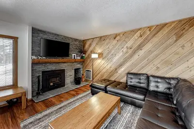 a living room with a leather couch and a fireplace at Snowcreek 27 in Mammoth Lakes