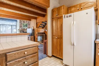 a kitchen with a white refrigerator and wooden cabinets at Spacious Winterset 26 2 Bedrm Plus Loft 3 Full Bathrm Townhome Sleeps 8 Steps to Free Town Shuttle in Mammoth Lakes