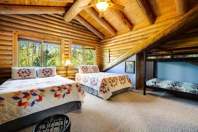 a bedroom with two beds in a log cabin at The Cub Inn in Groveland