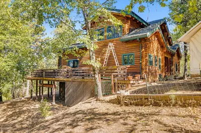 a log cabin with a deck in front of a house at The Cub Inn in Groveland