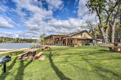 a building with picnic tables in the grass next to a lake at Hikers Escape Home Near Beach, Golf and Yosemite in Groveland