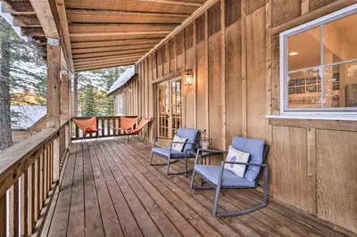 two chairs on the porch of a wooden house at Furnished Deck Cabin on Northstar Shuttle Route! in Truckee
