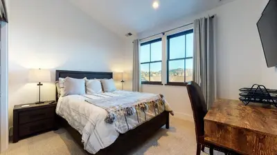 a bedroom with a bed and a table and window at Snowcreek VII #1403 condo in Mammoth Lakes