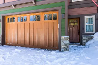 a house with a wooden garage door in the snow at Newly Updated Red Slate 4 is a 4 Bedrm 3 full Bathrm Townhome Close to Canyon Lodge That Sleeps 10 in Mammoth Lakes